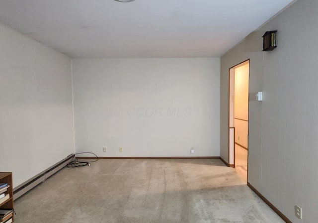 carpeted empty room featuring baseboard heating