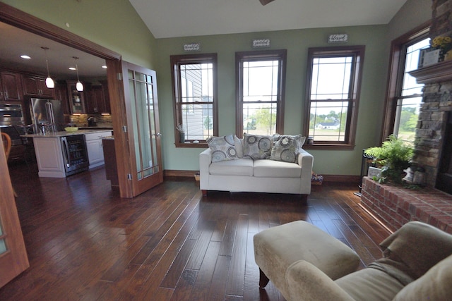 living room with a healthy amount of sunlight, lofted ceiling, dark wood-type flooring, and wine cooler