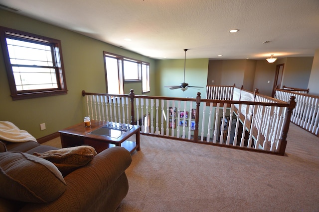 interior space featuring light carpet, a textured ceiling, and ceiling fan