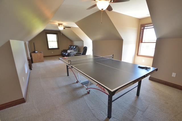 recreation room with ceiling fan, light carpet, and vaulted ceiling