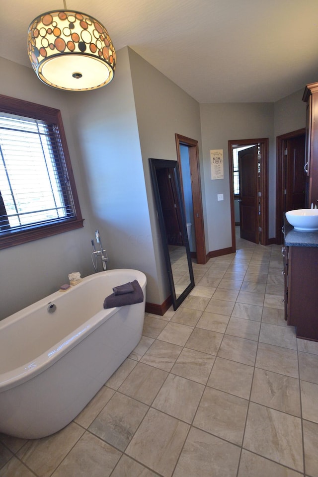 bathroom with tile patterned floors, a bathtub, and vanity