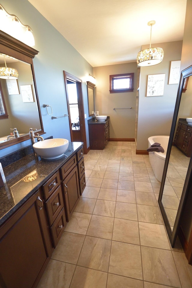 bathroom featuring tile patterned flooring, vanity, and a tub