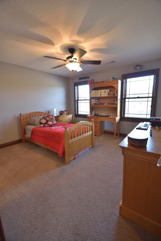 carpeted bedroom with ceiling fan and a textured ceiling