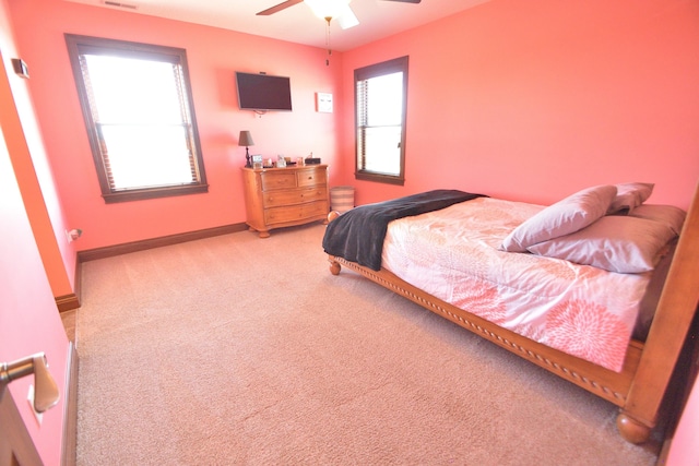 carpeted bedroom with ceiling fan and multiple windows