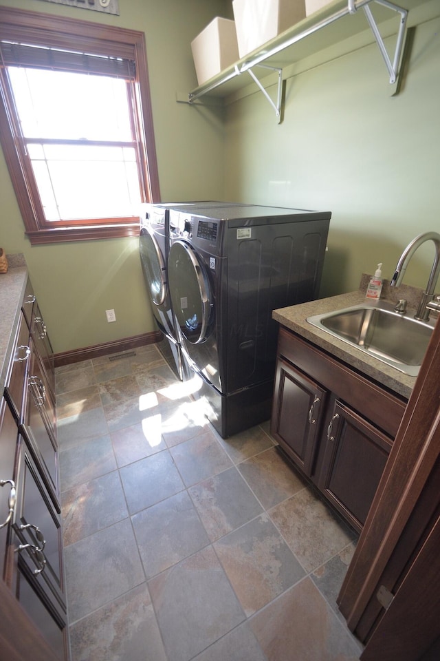 laundry area featuring cabinets, sink, and washer and dryer