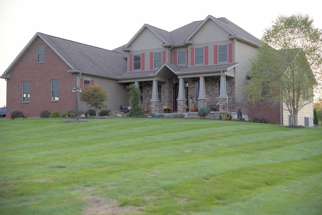 craftsman house featuring covered porch and a front yard