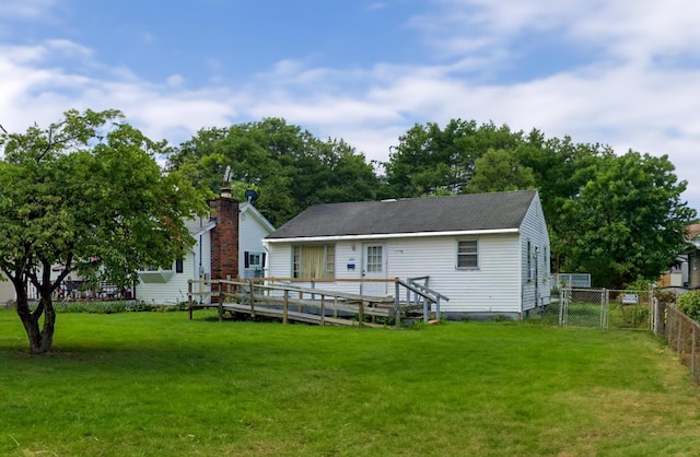 back of property with a yard and a deck