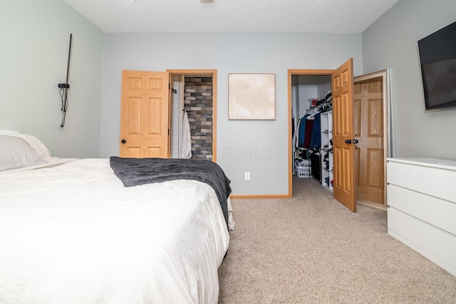 carpeted bedroom featuring a walk in closet, a textured ceiling, and a closet