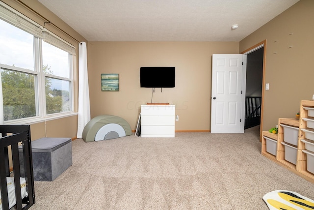 bedroom with light colored carpet and a textured ceiling