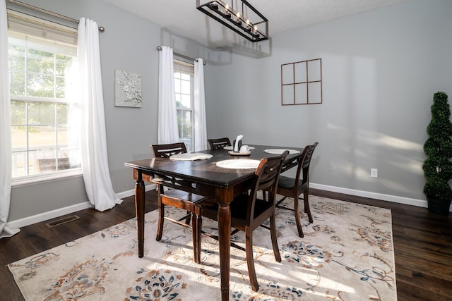 dining room featuring a textured ceiling, plenty of natural light, a chandelier, and dark hardwood / wood-style floors