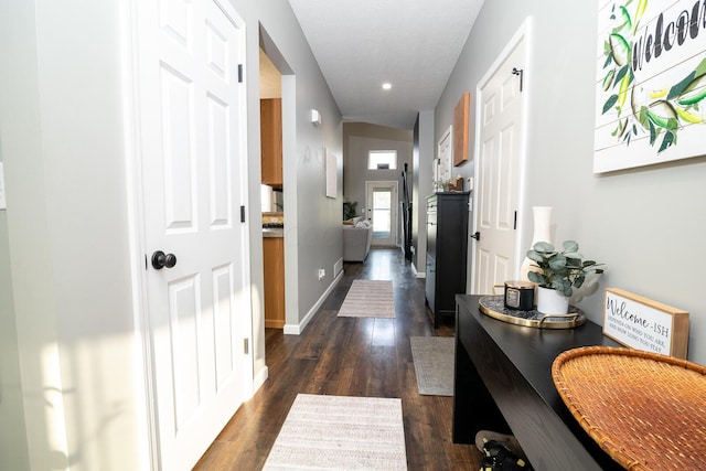 hall with dark hardwood / wood-style floors and lofted ceiling