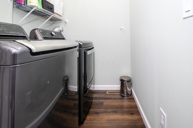 laundry room with washing machine and dryer and dark wood-type flooring