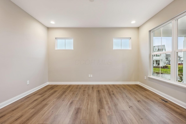 unfurnished room featuring light hardwood / wood-style floors and a wealth of natural light