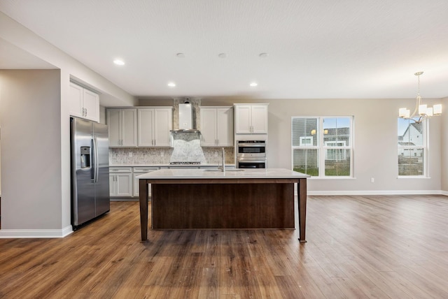 kitchen with white cabinets, appliances with stainless steel finishes, dark wood-type flooring, and wall chimney exhaust hood