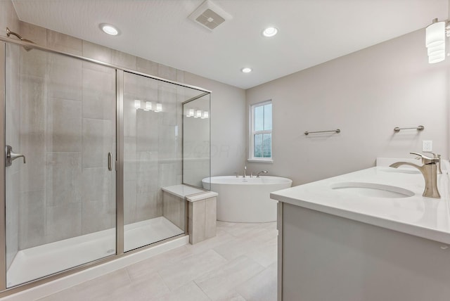 bathroom with vanity and shower with separate bathtub