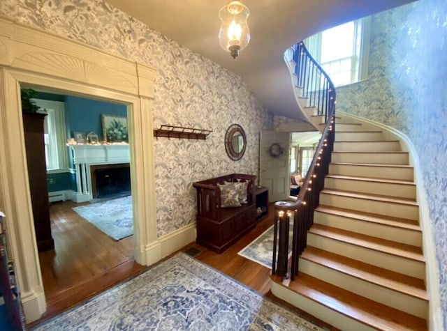 stairway with hardwood / wood-style flooring and vaulted ceiling