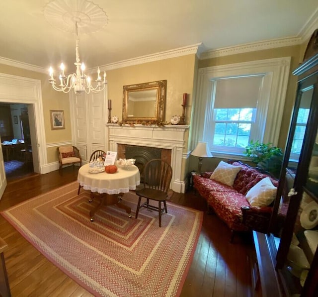 sitting room with dark hardwood / wood-style flooring, an inviting chandelier, and ornamental molding