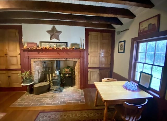 dining room with vaulted ceiling with beams and hardwood / wood-style floors