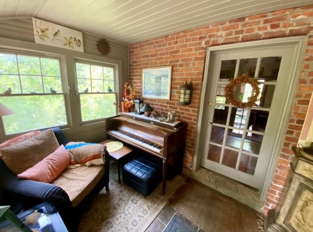 sitting room with hardwood / wood-style floors, wood ceiling, brick wall, and vaulted ceiling