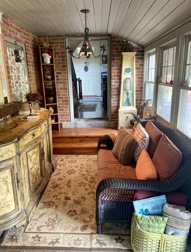 living room featuring wood ceiling, light hardwood / wood-style floors, and brick wall