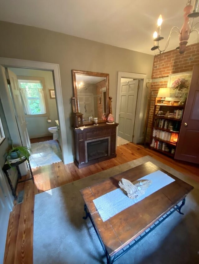 exercise room with a fireplace, a chandelier, and hardwood / wood-style flooring