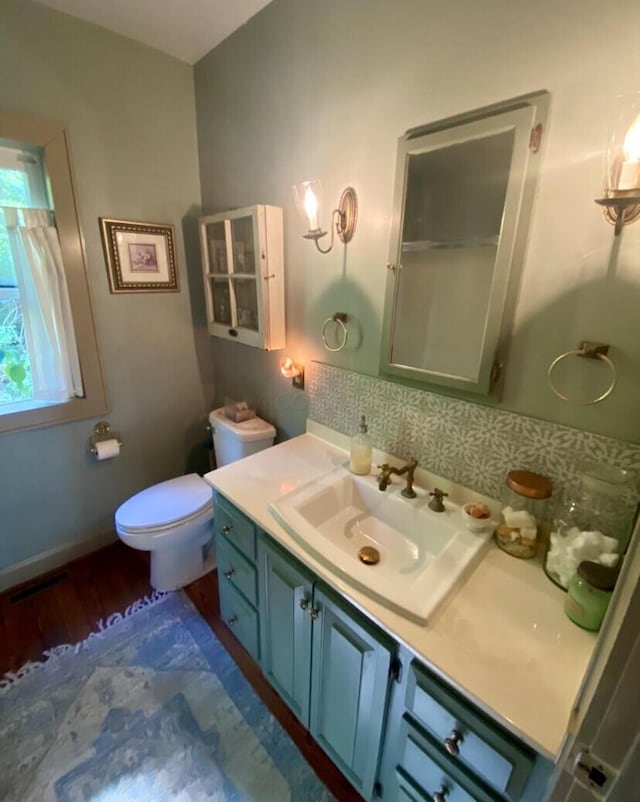 bathroom with vanity, hardwood / wood-style floors, backsplash, and toilet