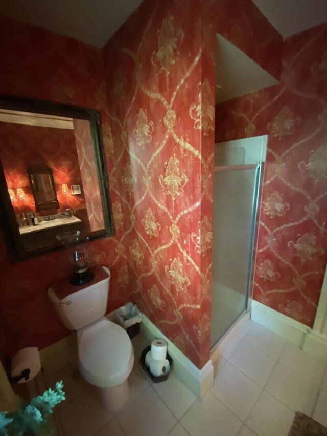 bathroom with tile patterned flooring, toilet, and walk in shower