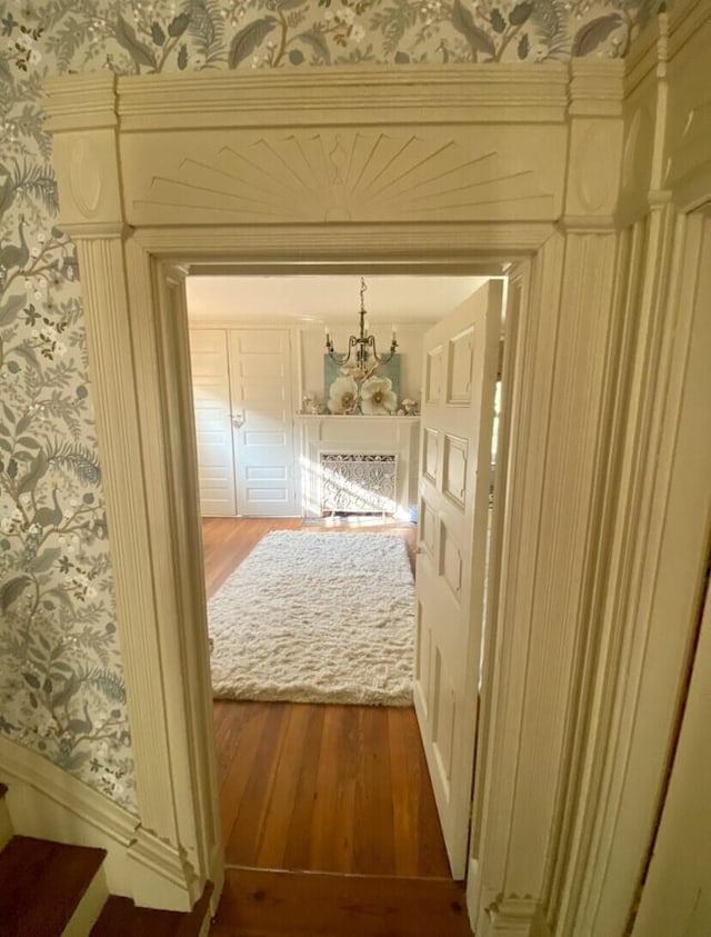 hallway featuring hardwood / wood-style flooring and an inviting chandelier