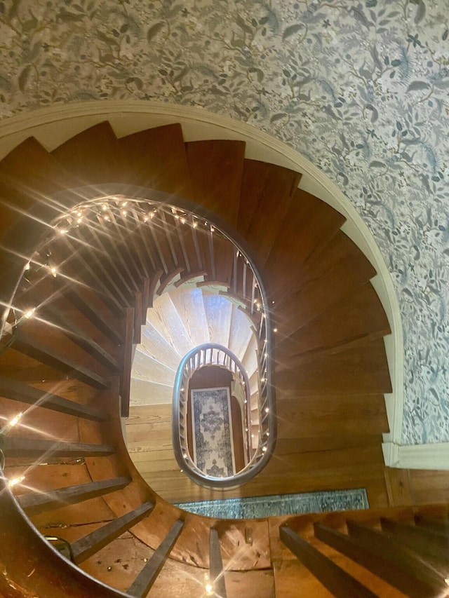 staircase featuring wooden walls