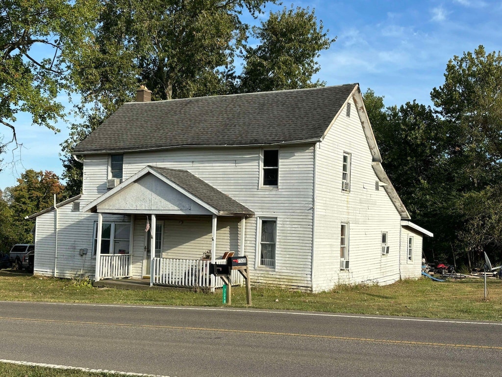 view of front of home with covered porch and a front lawn