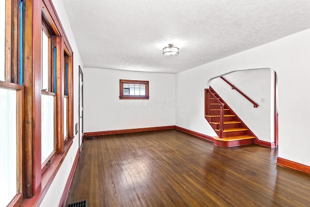 unfurnished room with a textured ceiling and dark hardwood / wood-style floors