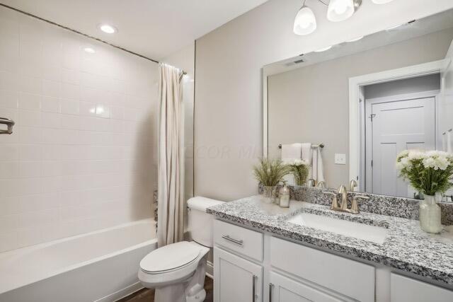 full bathroom featuring vanity, toilet, and shower / bathtub combination with curtain