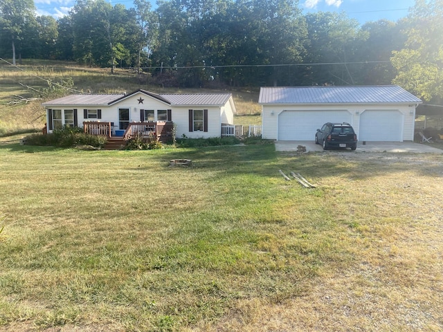 single story home with a deck, an outbuilding, a front yard, and a garage