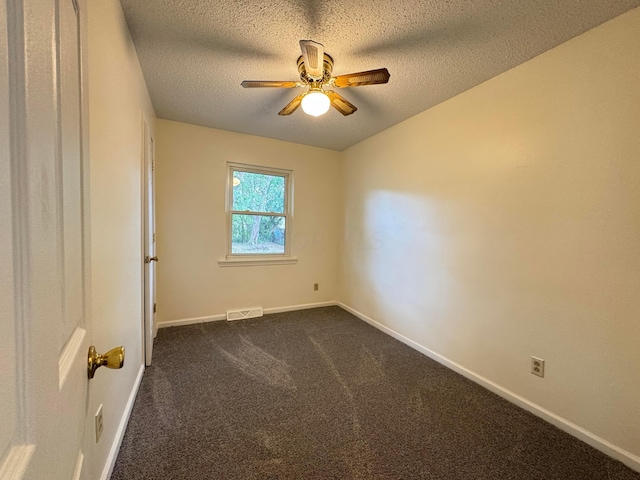 carpeted empty room with ceiling fan and a textured ceiling