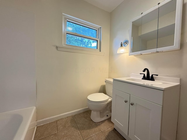 bathroom with tile patterned floors, a washtub, vanity, and toilet