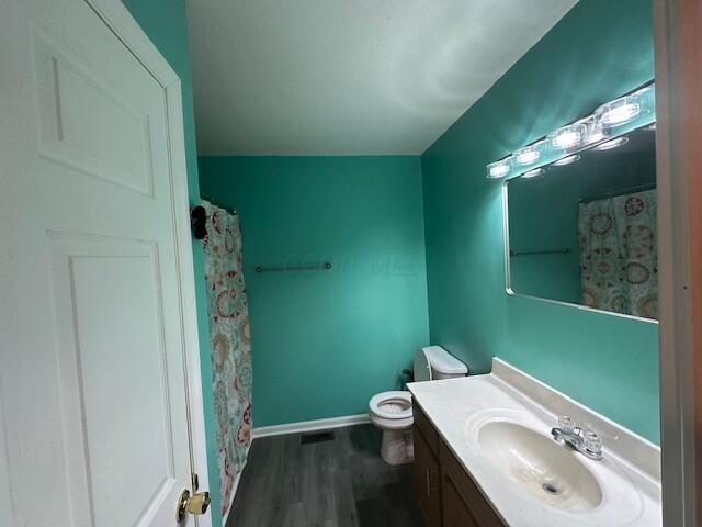 bathroom featuring a shower with shower curtain, vanity, hardwood / wood-style flooring, and toilet