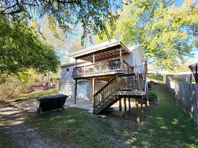 rear view of house featuring a lawn, a garage, and a deck