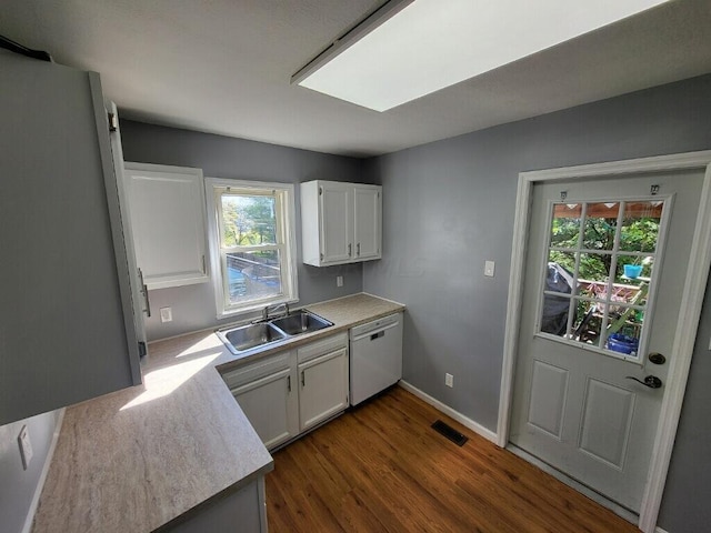 kitchen featuring white dishwasher, dark hardwood / wood-style flooring, white cabinets, and sink