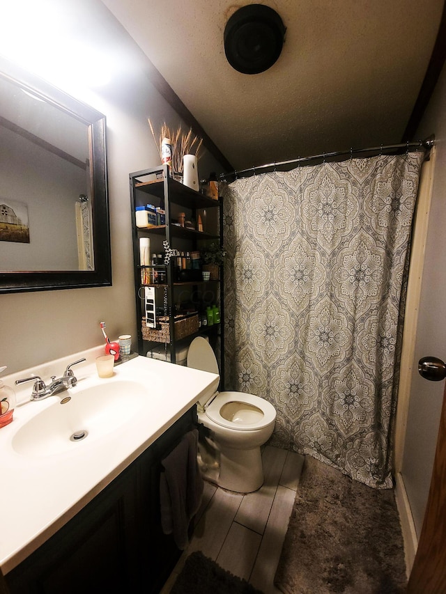 bathroom featuring curtained shower, hardwood / wood-style floors, a textured ceiling, toilet, and vanity