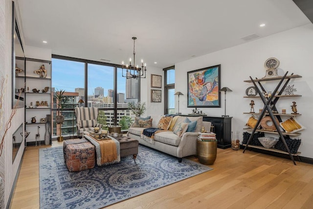 living room featuring a notable chandelier, floor to ceiling windows, and light hardwood / wood-style flooring