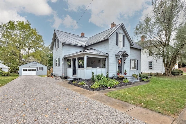 view of front of house featuring an outbuilding, a front yard, and a garage