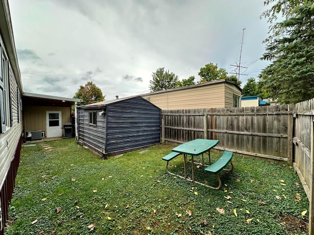 view of yard featuring central AC unit and a storage unit