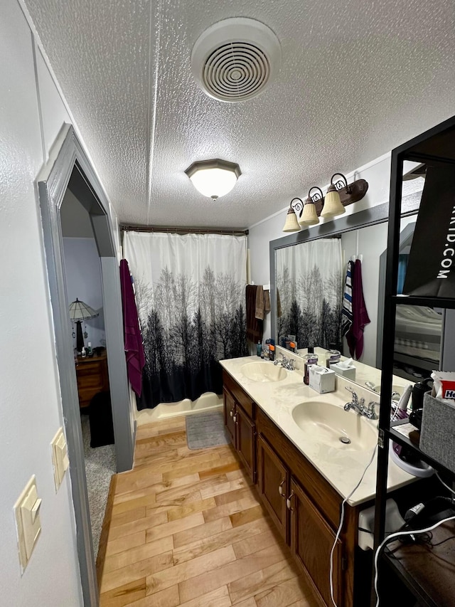 bathroom featuring hardwood / wood-style floors, vanity, and a textured ceiling