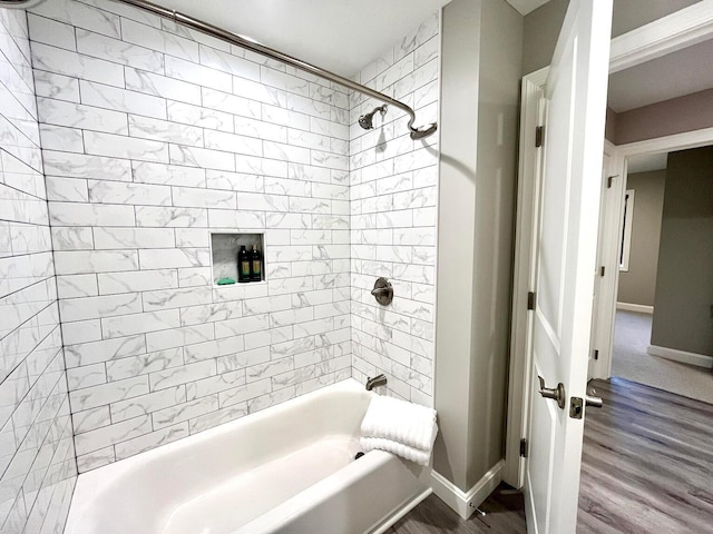 bathroom with wood-type flooring and tiled shower / bath