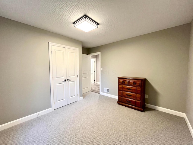 unfurnished bedroom with a textured ceiling and a closet