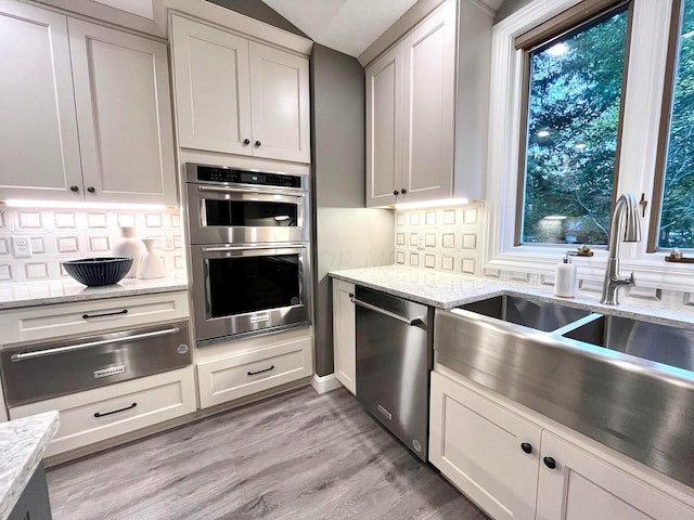 kitchen with white cabinets, appliances with stainless steel finishes, tasteful backsplash, and sink