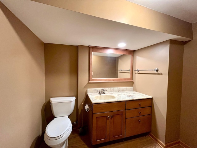 bathroom with hardwood / wood-style flooring, vanity, and toilet