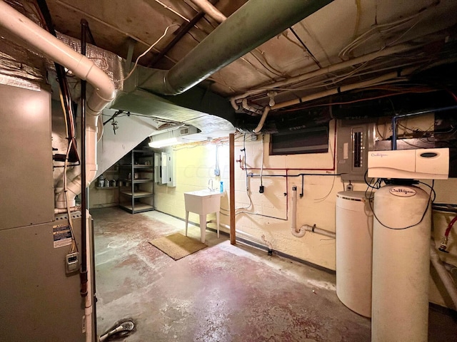 basement with sink, electric panel, and heating unit