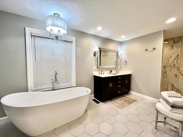 bathroom with a tub, vanity, a chandelier, and a textured ceiling