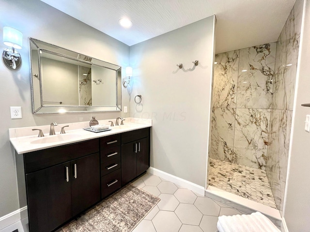 bathroom featuring tile patterned flooring, vanity, and tiled shower